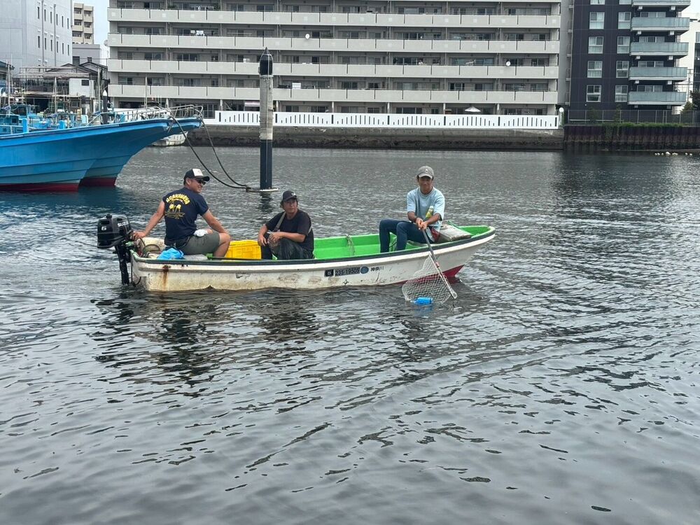小舟で湾内を回り清掃する様子