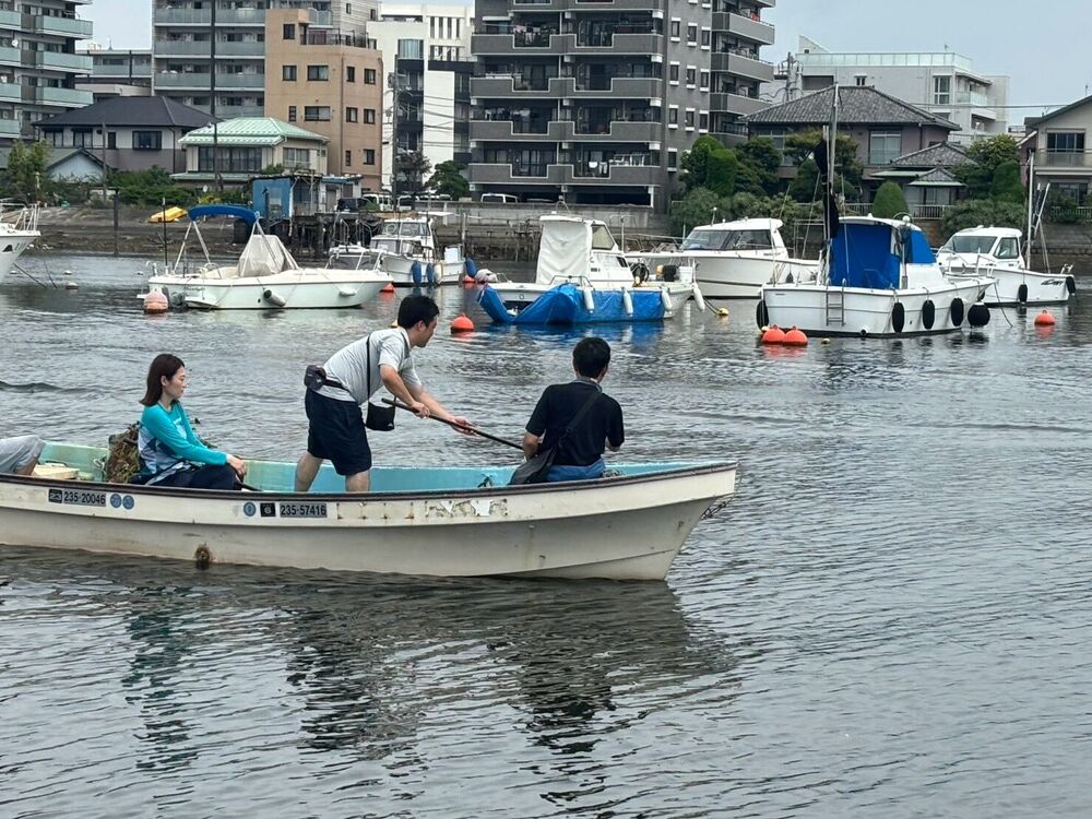 小舟でごみをすくい上げる様子